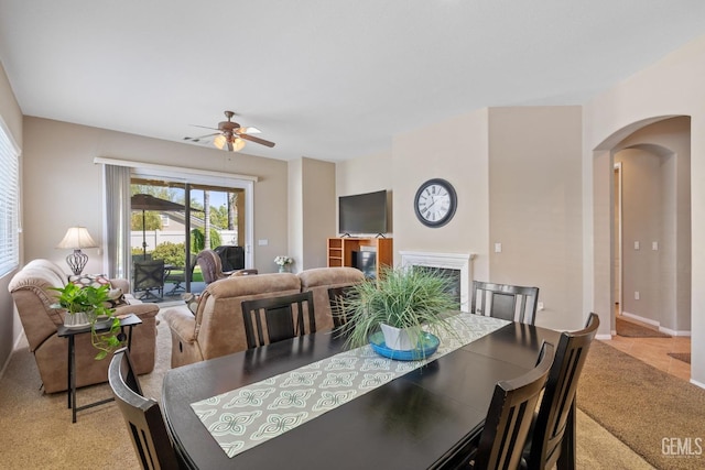 dining area with light carpet and ceiling fan