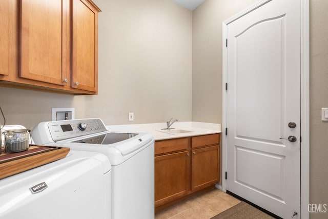 laundry area featuring cabinets, separate washer and dryer, sink, and light tile patterned floors