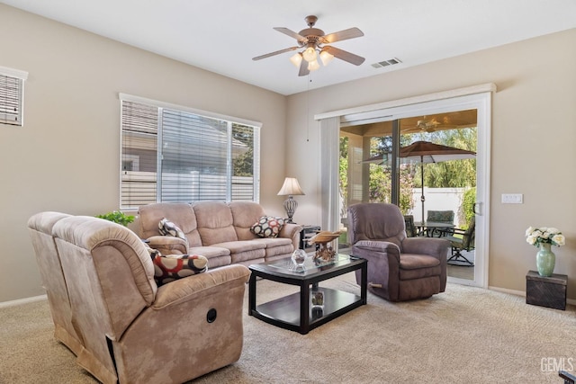 living room featuring light carpet, plenty of natural light, and ceiling fan