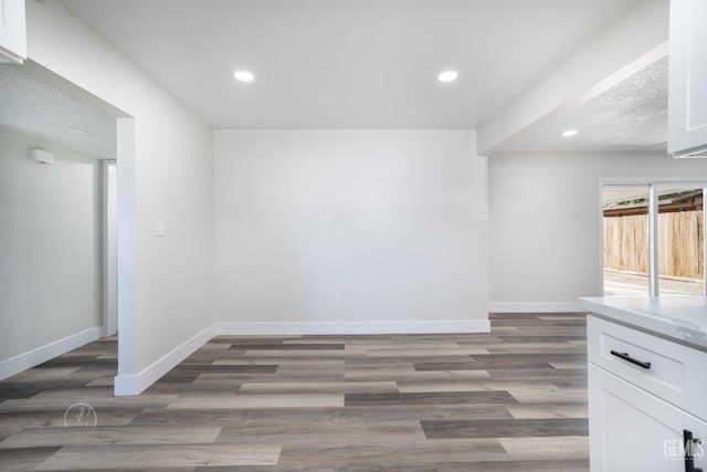 interior space with baseboards, recessed lighting, and wood finished floors