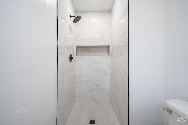 bathroom featuring toilet and tiled shower