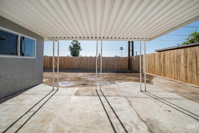 view of patio / terrace with a fenced backyard and an attached carport