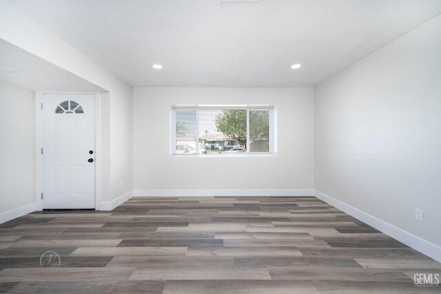 entryway featuring wood finished floors, baseboards, and recessed lighting