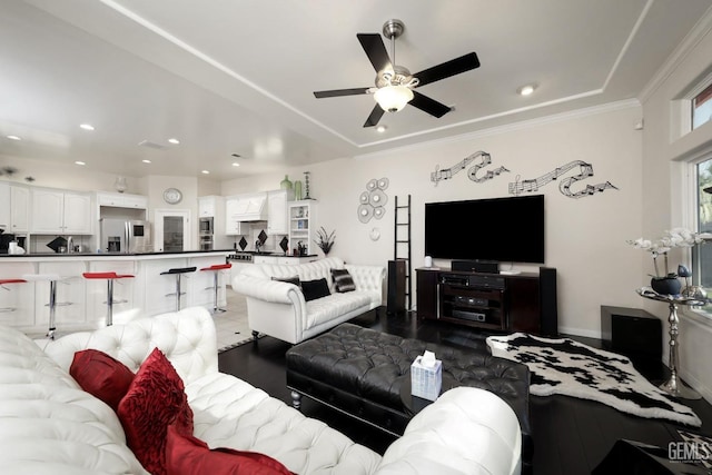 tiled living room with ceiling fan and ornamental molding