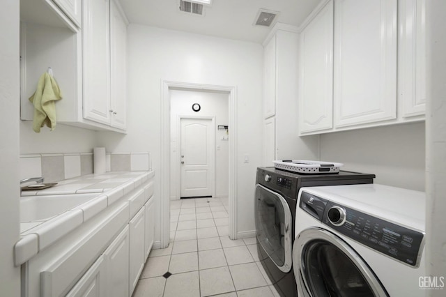 washroom featuring washer and dryer, cabinets, light tile patterned floors, and sink