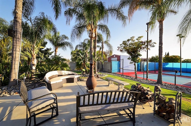 view of home's community with an outdoor hangout area, tennis court, and a storage unit