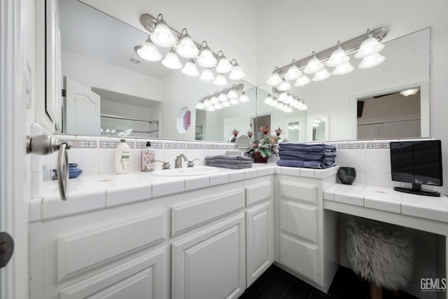 bathroom with vanity, decorative backsplash, tile patterned floors, and walk in shower