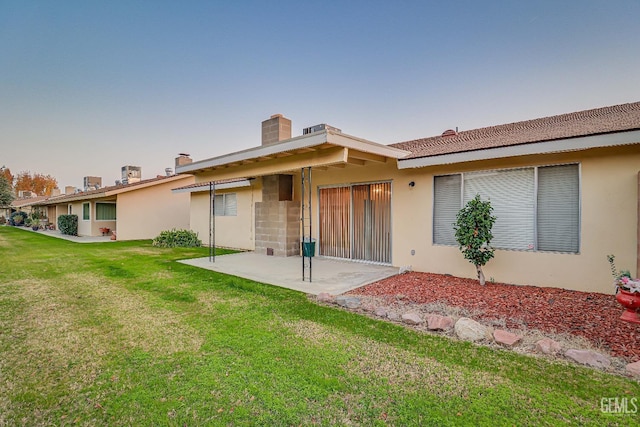 back of property featuring a patio and a lawn