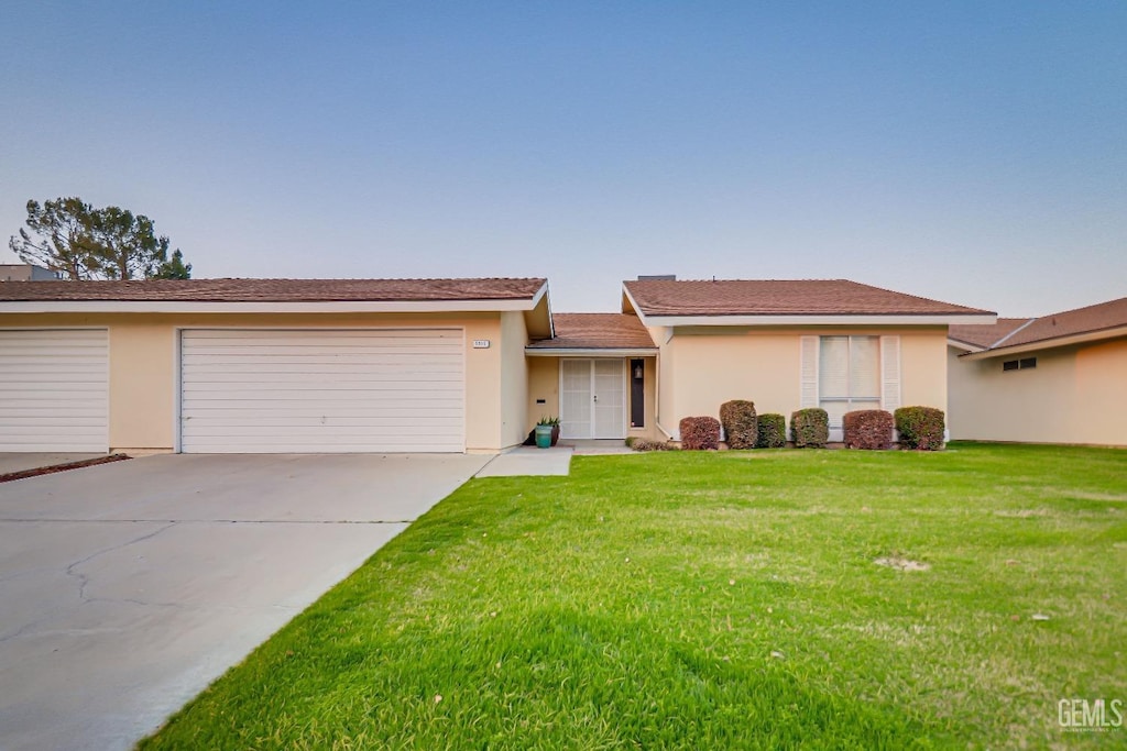 single story home with a garage and a front yard