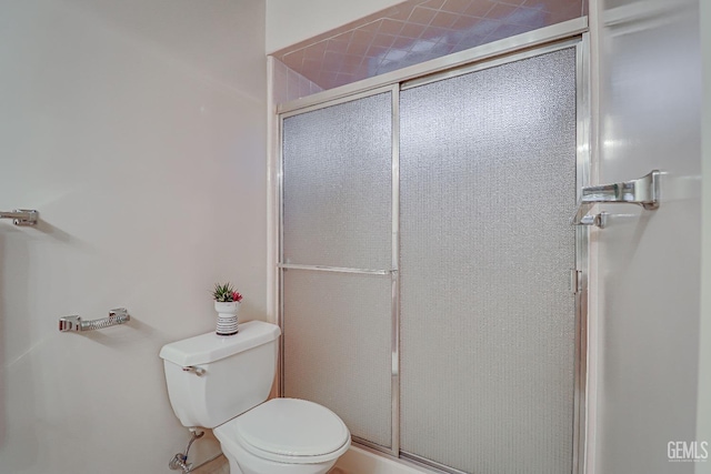 bathroom with toilet and a shower with door