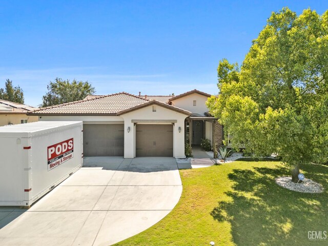 2004 Suncrisp Ln, Bakersfield, CA 93312 - view of front of home featuring an attached garage, driveway, a front lawn, stucco siding, and a tile roof