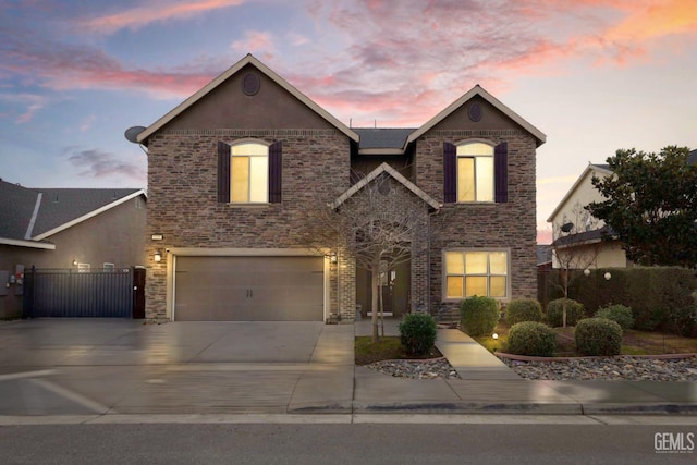 traditional-style house with an attached garage, driveway, fence, and stone siding