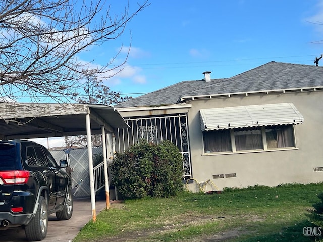 view of side of home with a carport and a lawn