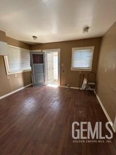 unfurnished living room with baseboards and wood finished floors