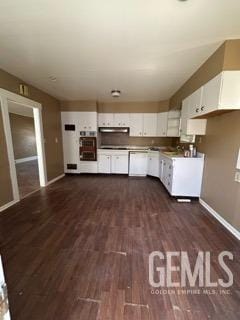 kitchen with white cabinets, dark wood-style flooring, baseboards, and under cabinet range hood