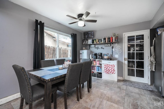 dining space featuring a ceiling fan and baseboards