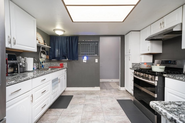 kitchen with gas stove, under cabinet range hood, white cabinets, and a sink