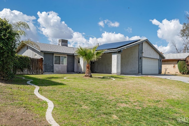 view of front of house featuring stucco siding, fence, a front yard, a garage, and solar panels