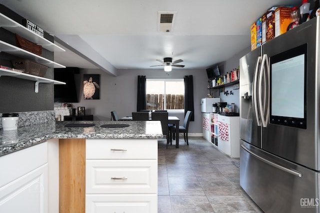 kitchen featuring visible vents, open shelves, white cabinetry, a peninsula, and stainless steel fridge with ice dispenser