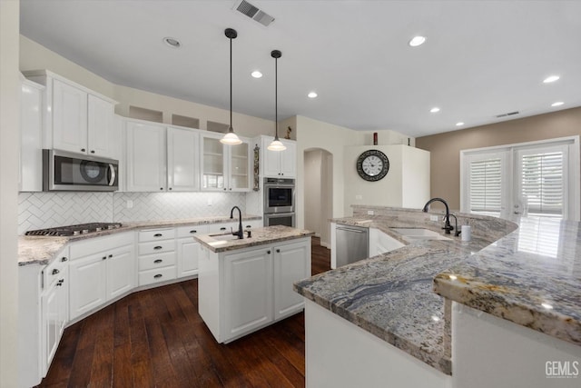 9508 Canyon Lake Ct, Bakersfield, CA 93312 - kitchen with a large island, visible vents, arched walkways, a sink, and stainless steel appliances