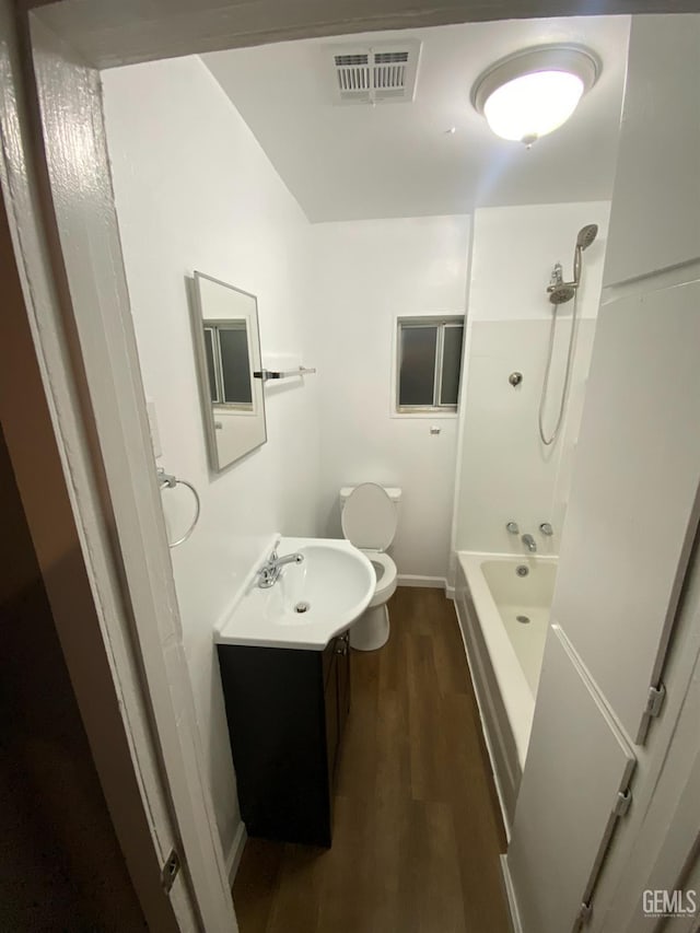 full bathroom with hardwood / wood-style floors, vanity, toilet, and bathtub / shower combination