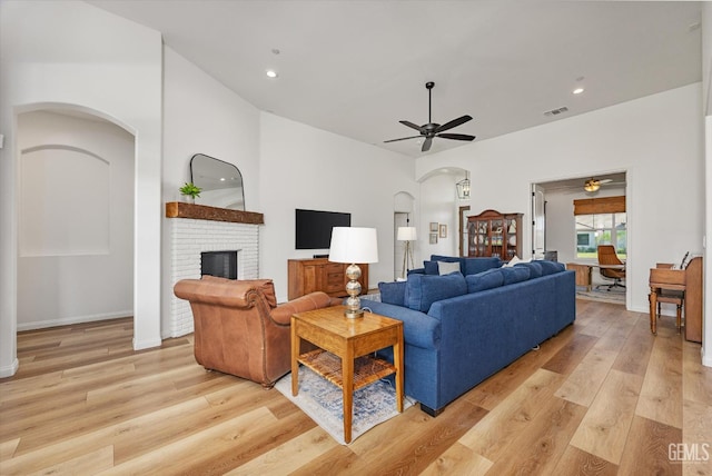 16711 Keystone Pl, Bakersfield, CA 93314 - living room featuring arched walkways, a ceiling fan, light wood-style floors, a brick fireplace, and recessed lighting