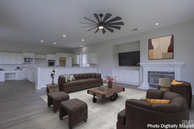1715 Norwich Way, Bakersfield, CA 93311 - living area with a ceiling fan, recessed lighting, light wood-style floors, and a glass covered fireplace