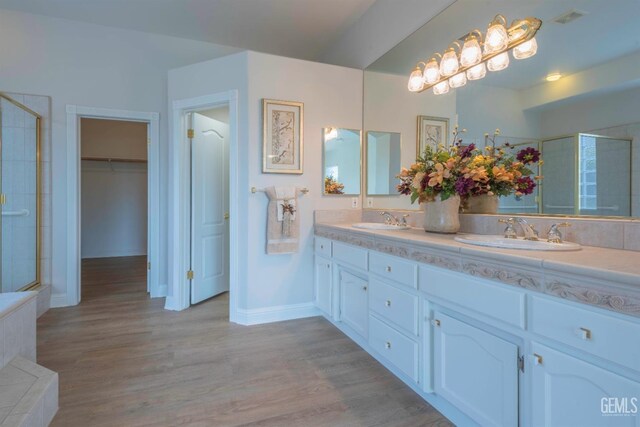 1715 Norwich Way, Bakersfield, CA 93311 - bathroom with double vanity, a tile shower, wood finished floors, and a spacious closet