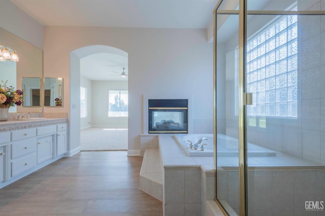 1715 Norwich Way, Bakersfield, CA 93311 - bathroom featuring vanity, ceiling fan, wood finished floors, a garden tub, and a multi sided fireplace
