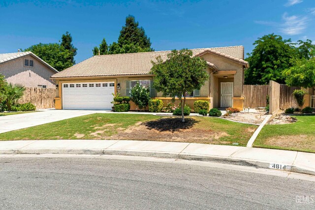 4810 Bluestone Dr, Bakersfield, CA 93311 - view of front of house featuring a tile roof, an attached garage, concrete driveway, and stucco siding