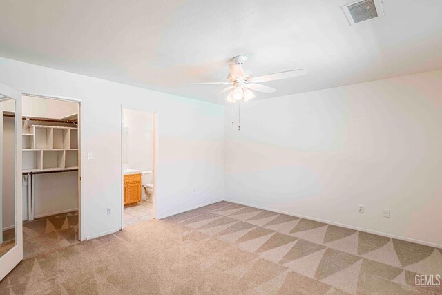 4810 Bluestone Dr, Bakersfield, CA 93311 - unfurnished bedroom featuring light carpet, a spacious closet, a closet, a ceiling fan, and connected bathroom