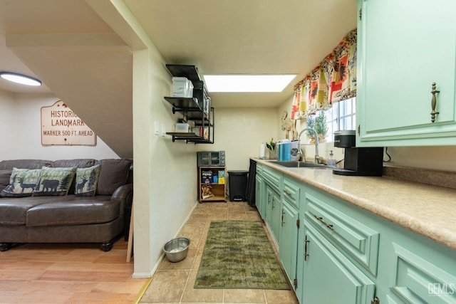 kitchen featuring sink, light tile patterned flooring, and green cabinetry