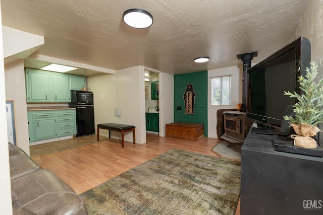 living room featuring light hardwood / wood-style flooring and a wood stove