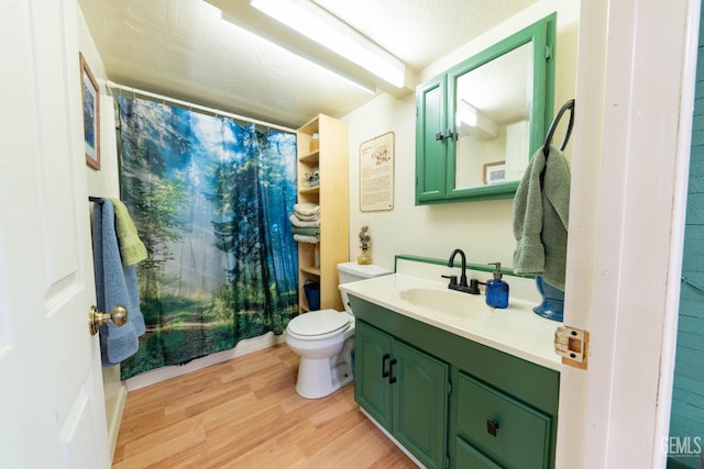 bathroom with a shower with shower curtain, hardwood / wood-style floors, vanity, and toilet