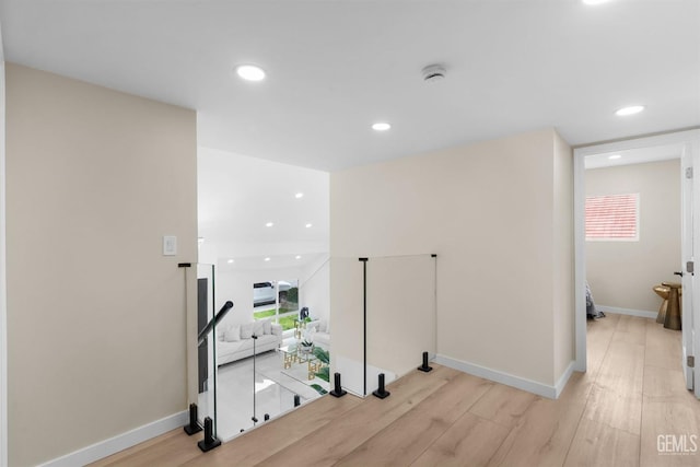 hall with baseboards, light wood-type flooring, plenty of natural light, and recessed lighting