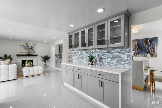 interior space with tasteful backsplash, marble finish floor, a fireplace, and recessed lighting