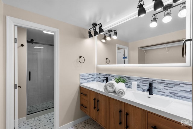 bathroom with decorative backsplash, double vanity, a sink, baseboards, and a stall shower