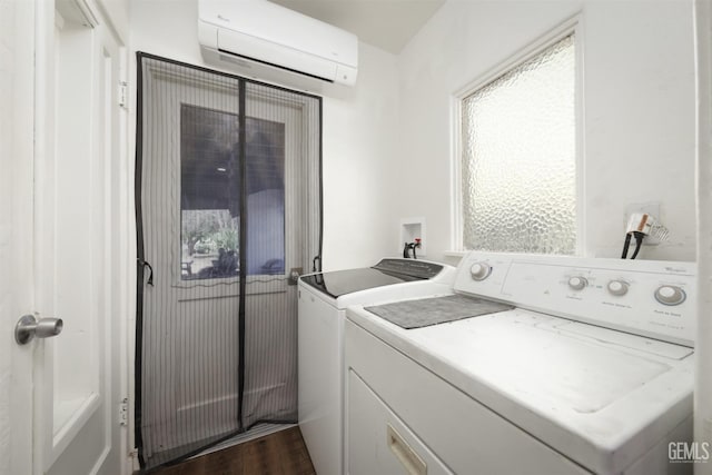 laundry area with a wall mounted air conditioner, dark wood-style flooring, washing machine and dryer, and laundry area