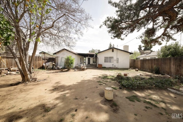 back of house featuring stucco siding and a fenced backyard