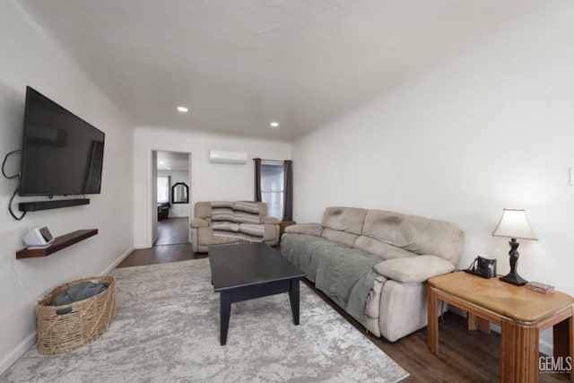 living area with a wall mounted air conditioner, baseboards, and wood finished floors