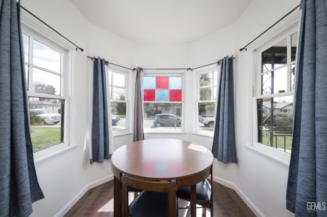 dining space featuring baseboards and dark wood-style flooring