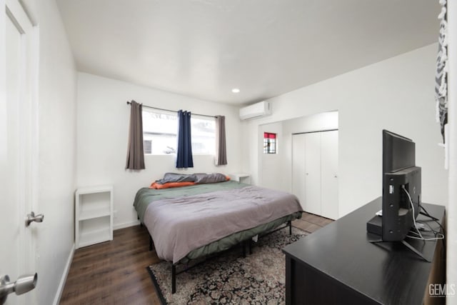 bedroom with a wall mounted AC, wood finished floors, recessed lighting, a closet, and baseboards