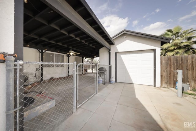 exterior space featuring concrete driveway, a gate, fence, and ceiling fan