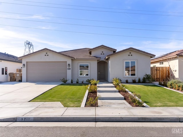 view of front of property featuring a garage, a front yard, concrete driveway, and stucco siding