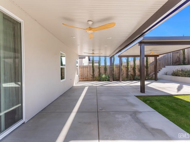 view of patio with ceiling fan and fence