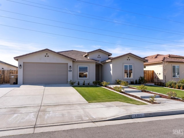 view of front of home with a garage, concrete driveway, a front lawn, and fence