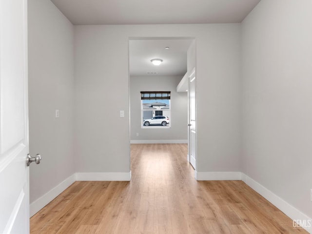 hall with light wood finished floors and baseboards