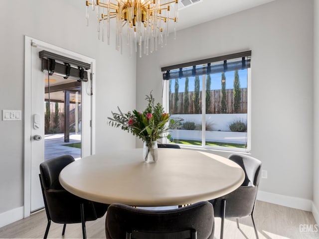 dining space featuring light wood-style flooring and baseboards