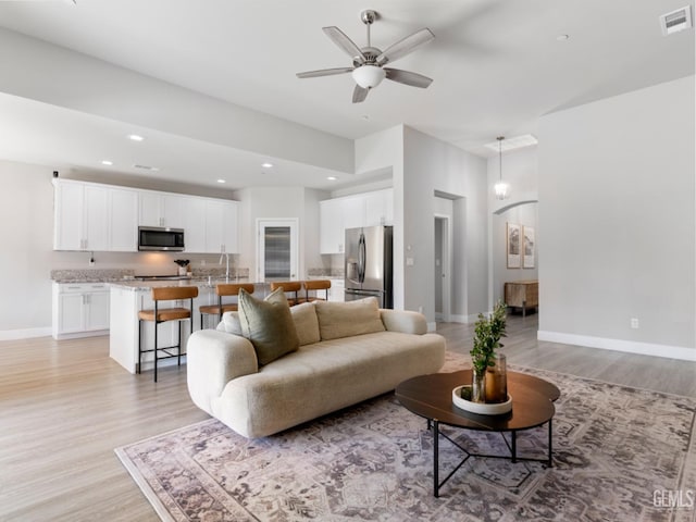 living area featuring light wood-style flooring, visible vents, baseboards, and recessed lighting