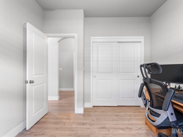 office space with light wood-type flooring and baseboards